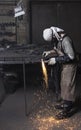 Metalworker cutting on steel plate creating sparks, cutting iron