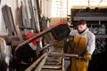 Metalworker cutting tubes on saw machine