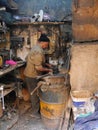 Metalworker in his untidy workplace with tools around him,Fez, Morocco