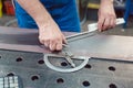 Metalworker using folding rule to measure steel strip