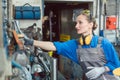 Metalworker woman in workshop grabbing tool