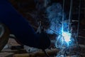 Metalworker at work welding steel with spread spark and lighting around.Hand of Steel Workers welding steel bar construction Royalty Free Stock Photo