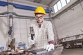 Metalworker works metal with hammer on the anvil