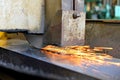 Metalworking industry: finishing metal working on horizontal surface grinder machine with flying sparks Royalty Free Stock Photo