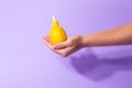 Metaphor, bottle serum with vitamin C for skin in lemon in female hand. The concept vegetable cosmetics and aromatherapy