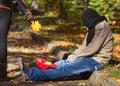 Metaphoric social photo with tramp man begging in autumnal park Royalty Free Stock Photo