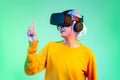 Metaverse concept woman wearing vr goggles headset finger pointing touching playing looking on the green screen background Royalty Free Stock Photo