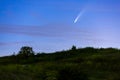 Meteor, shooting star or falling star seen in a night sky with clouds. Comet NEOWISE, C/2020 F3