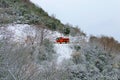Snow plow truck on snowy road in action. Gritter vehicle spreading deicing salt. Winter landscape after snowfall.
