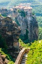 Panoramic view from Meteoron Monastery cliff stone stairs with metal railings on scenic Meteora landscape rock formations with Royalty Free Stock Photo