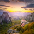 Meteora, Greece at romantic sundown time with real sun and sunset sky. Meteora - incredible sandstone rock formations. The Royalty Free Stock Photo