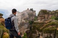 Meteora - Man with scenic view of Holy Monastery of Great Meteoron appearing from fog, Kalambaka, Meteora Royalty Free Stock Photo