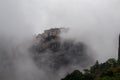 Meteora - Panoramic view of Holy Monastery of Varlaam surrounded by misty fog on cloudy day, Kalambaka, Meteora
