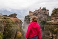 Meteora - Woman with scenic view of Holy Monastery of Great Meteoron appearing from fog, Kalambaka, Meteora Royalty Free Stock Photo