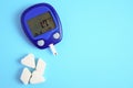 The meter is insulated on a blue background. Blood sugar measurements. The concept of diabetes. Hypoglycemia. Copy space