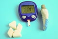 The meter is insulated on a blue background. Blood sugar measurements. The concept of diabetes. Hypoglycemia. Copy space