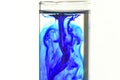 Methylene blue fall in water in glass tube Royalty Free Stock Photo