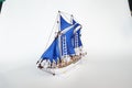 Detailed Model Sailboat with Blue Sails on White Background Royalty Free Stock Photo