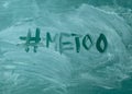 Metoo hashtag it handwritten with white chalk on a green blackboard