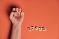 MeToo on wooden alphabet, used for concept of sexual harrassment. Woman fist as protest in shot Royalty Free Stock Photo