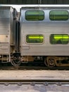 Metra train on railroad tracks in terminal of train station in Chicago, with view through window of passenger taking a seat Royalty Free Stock Photo