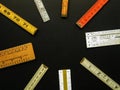 Metric and inch folding rulers in a circle with copy space suggest measurement, accuracy.