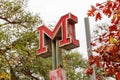 Metro M sign of the Metropolitan subway with autumn leaf\'s in the background in Lisbon Portugal