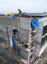 Metro Manila, Philippines - Construction workers doing finishing works on the firewall of a mid-rise office building