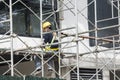 Metro Manila, Philippines - A sole construction worker on scaffolding doing final finishing works on the exterior