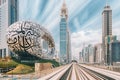 Metro railway among among glass skyscrapers in Dubai. Traffic on street in Dubai. Museum of the Future in Dubai