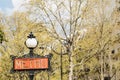 Metro sign in Paris in early springtime with yellow foliage