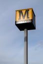 Metro sign on a tall pole with the sky behind it. Tyneside metro light rail network in North East England