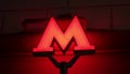 The metro symbol glows on the night street. A large red letter M indicating a subway close-up. Royalty Free Stock Photo