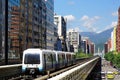 A Metro train travel on elevated rails of Wenhu Line of Taipei MRT System by office towers under blue clear sky Royalty Free Stock Photo