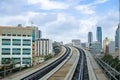 Metromover rails passing at height between modern buildings and skyscrapers.