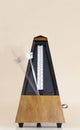Metronome with Blurred Moving Arm Brown Background Royalty Free Stock Photo