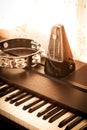 Metronome on a piano with tambourine. Royalty Free Stock Photo