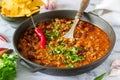 Mexican and American food Chili con carne served with nachos, pepper and herbs. Royalty Free Stock Photo