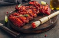 Mexican barbecued ribs seasoned with a spicy tomato sauce served on a wooden chopping board on a dark background Royalty Free Stock Photo