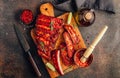 Mexican barbecued ribs seasoned with a spicy tomato sauce served on a wooden chopping board on a dark background. Royalty Free Stock Photo