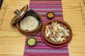 Mexican beef alambre recipe with lots of melted cheese, guacamole and mole sauce, corn tortillas in clay