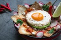 Mexican breakfast: chilaquiles with egg, avocado and vegetables close-up on a plate Royalty Free Stock Photo