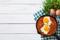 Mexican breakfast: Huevos rancheros in iron frying pan on white wooden table top view Royalty Free Stock Photo