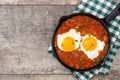 Mexican breakfast: Huevos rancheros in iron frying pan on wood Royalty Free Stock Photo