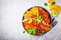 Mexican chicken burrito bowl with rice, beans, tomato, avocado,corn and spinach, top view. Mexican cuisine food concept