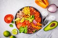 Mexican chicken burrito bowl with rice, beans, tomato, avocado,corn and spinach, top view. Mexican cuisine food concept