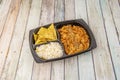 Mexican chicken tinga stew takeaway tray with white rice, corn chips, peas Royalty Free Stock Photo