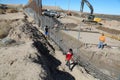 Mexican children observe the American workers who build the wall