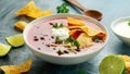 Mexican Chilli bean soup with yogurt, cheese, lime and tortilla chips in white bowl Royalty Free Stock Photo