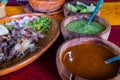 Mexican chopped lamb meat, hot sauces, and lime slices on colorful tablecloth